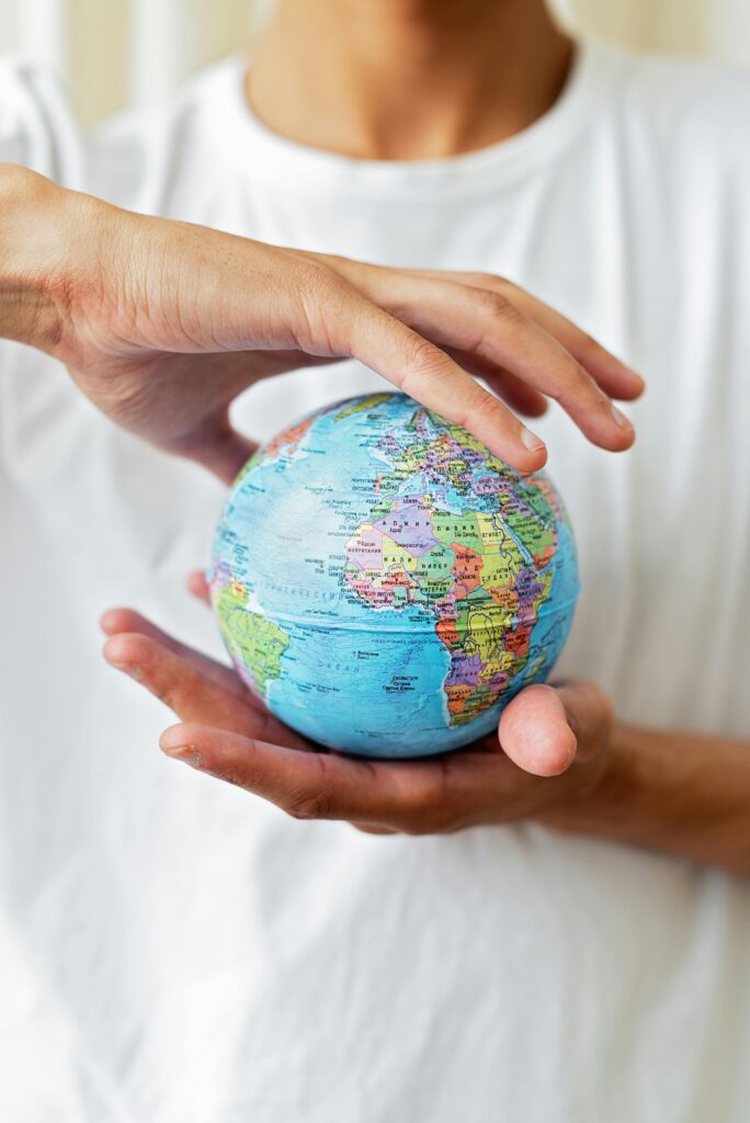 pexels-photo-8542360-8542360 Close-up of hands holding a world globe symbolizing global unity and environmental care.